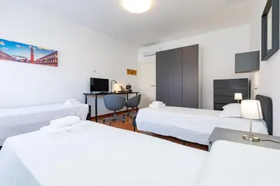 Letto o letti in una camera di Fucini Rooms Mestre Posizione strategica e comfort moderno
